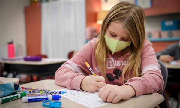 Girl works on paper kite